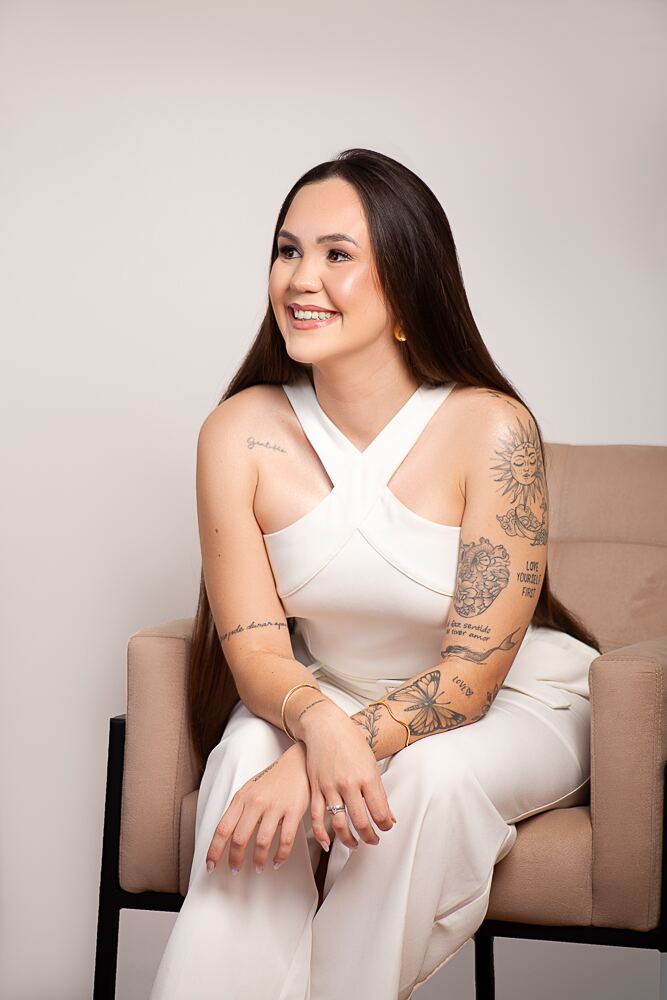 Laura Cortez sentada sorrindo durante ensaio profissional